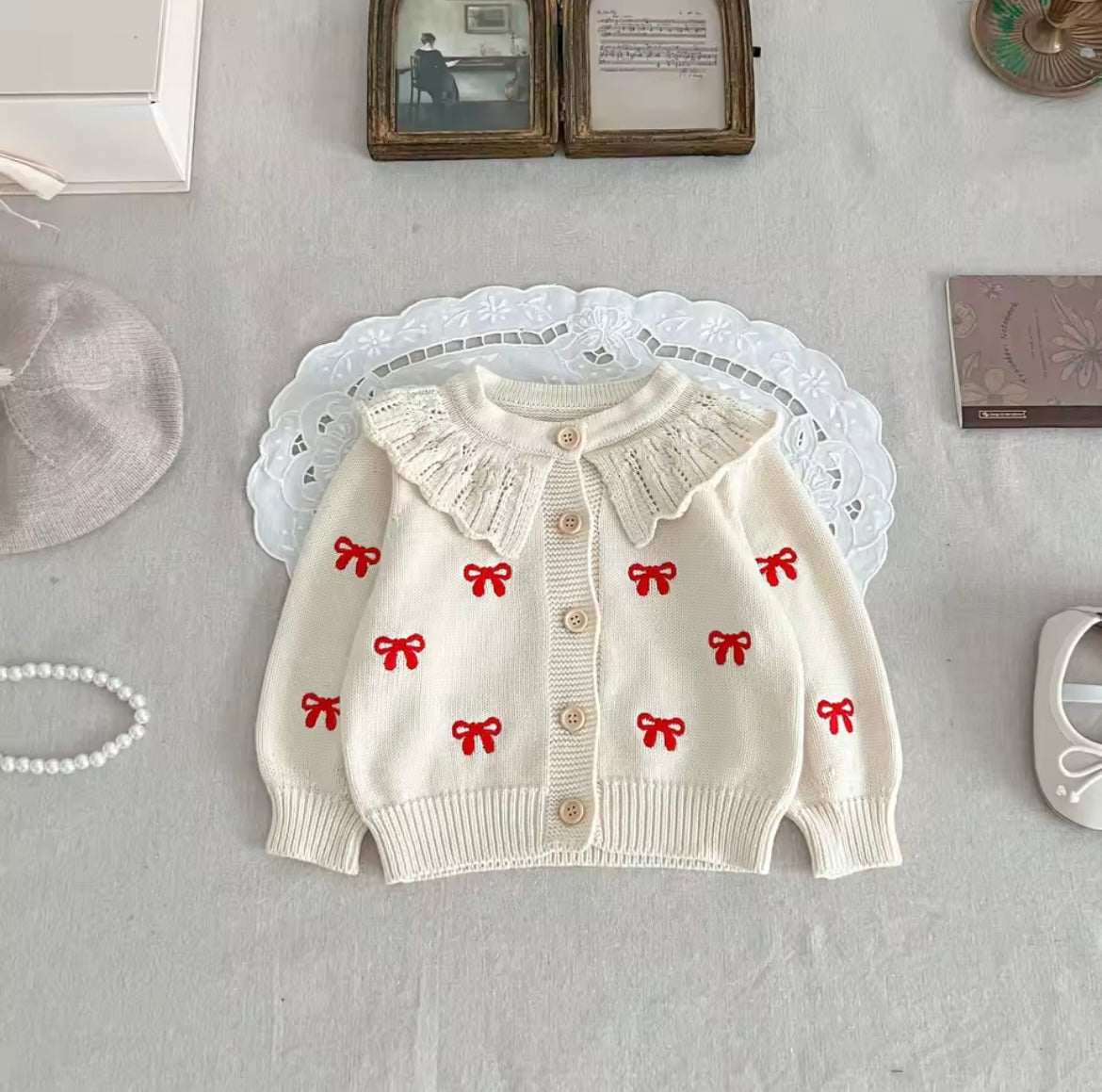 Cream cardigan and romper with red bow detail
