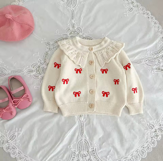 Cream cardigan and romper with red bow detail
